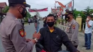 Foto: Kapolsek Bilah Hulu AKP R.P Panjaitan, SH memberikan imbauan kepada pengendara sepeda motor agar memakai masker.